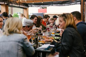 A group of people gathered around a table in a restaurant, eating