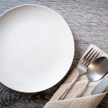 An empty plate with a knife and fork on the side