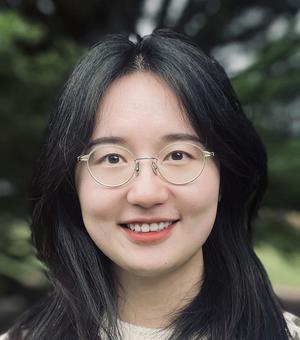 A woman with long dark hair smiles at the camera. 