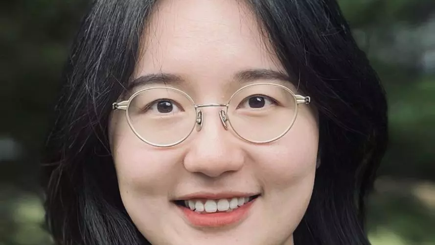 A woman with long dark hair smiles at the camera. 